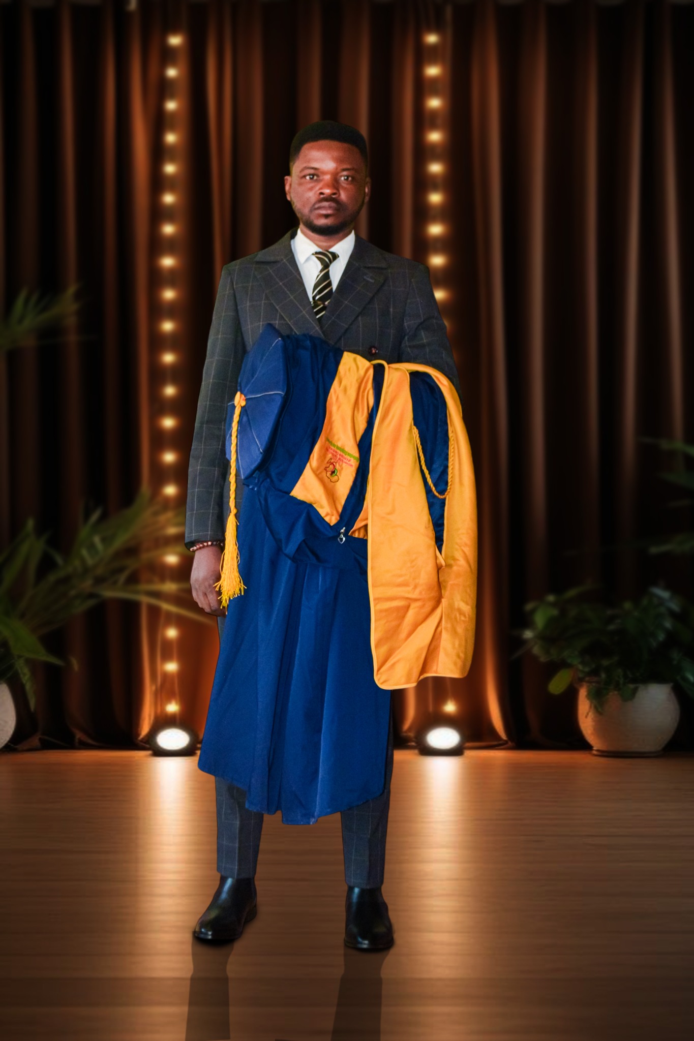 Dr. Abanda Emmanuel C. holding his graduation gown